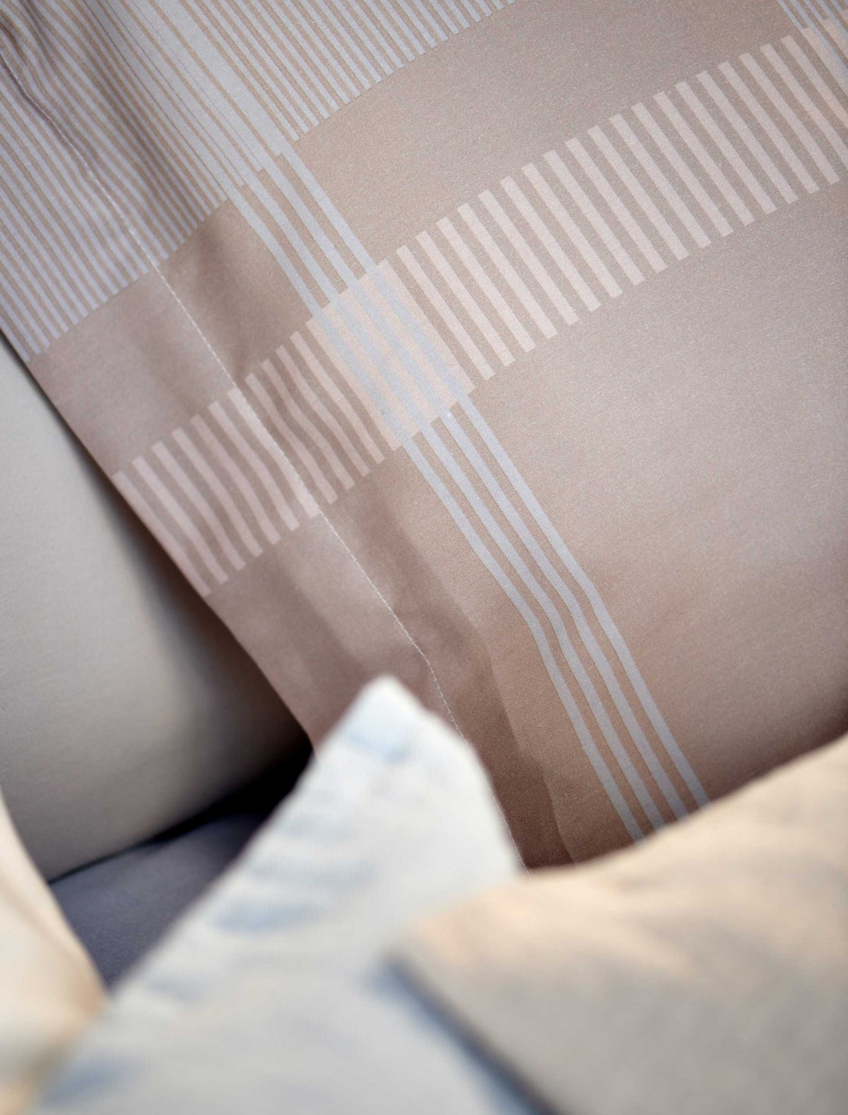 detail shot van een hoofdkussen met een beige kleur en een grafische print